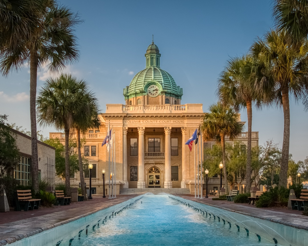 Historic Volusia County Courthouse with copper dome from fountain pool in DeLand, Florida.