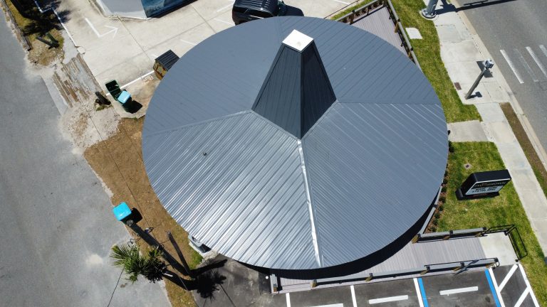 Aerial view of a circular standing-seam metal roof on a commercial building in Central Florida