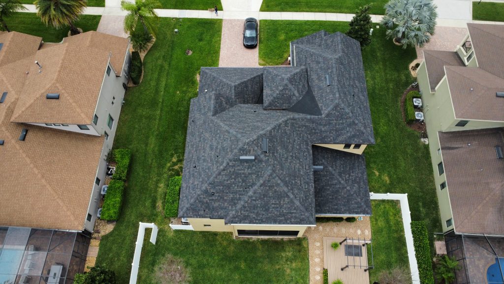 Aerial view of a newly installed dark gray shingle roof on a two-story home in Central Florida