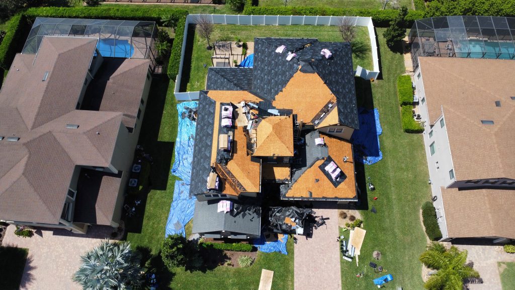 Aerial view of a Blitz Roofing crew tearing off and re-decking a shingle roof mid-project in Central Florida
